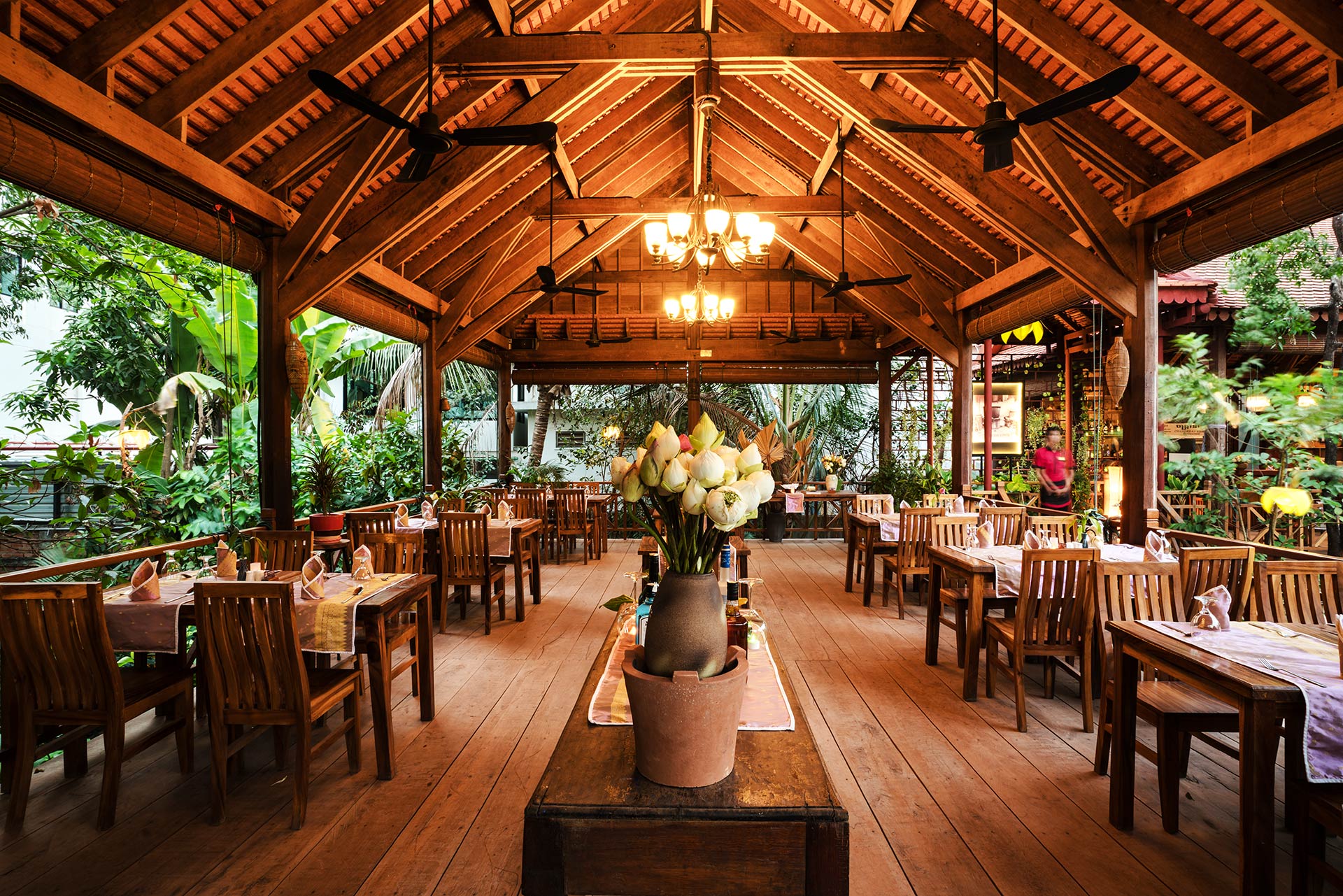 Chef Ly Seng teaching guests in a traditional wooden Khmer cooking house in Siem Reap